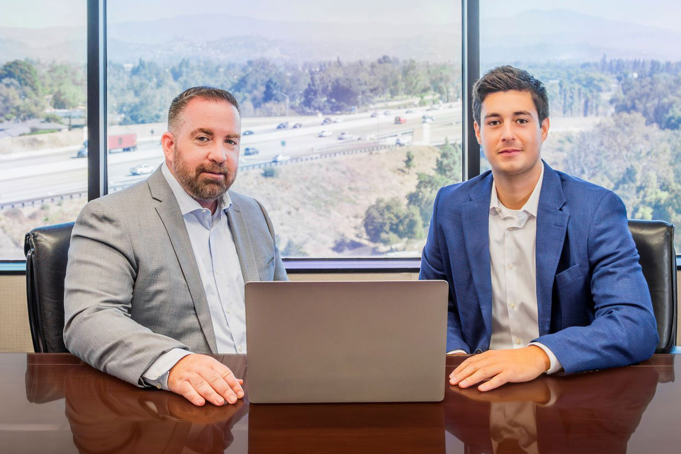 Home 11 - Broker Dev Team – Word & Brown Photo of Jim and Noah sitting at a table in a conference room.